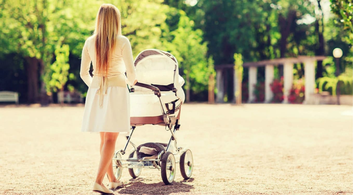 O mămică își plimbă bebelușul în cărucior