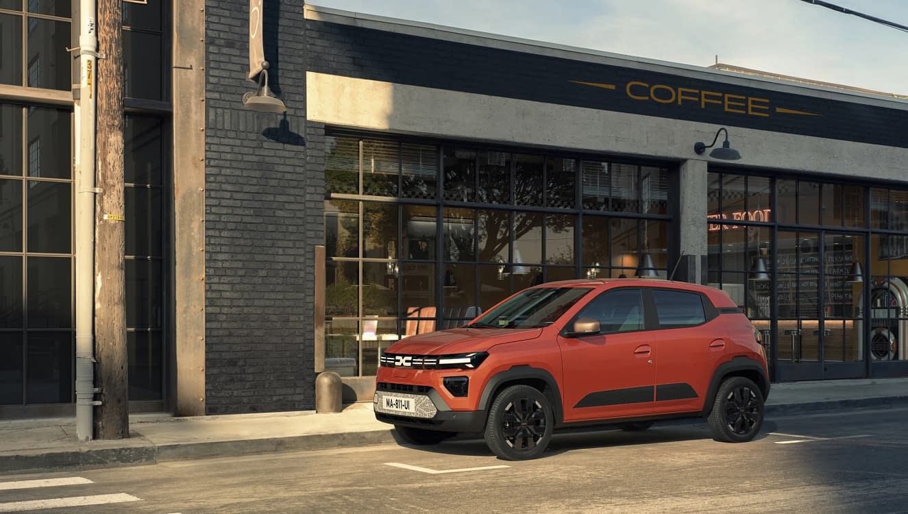 Dacia Spring parcată în fața unei cafenele