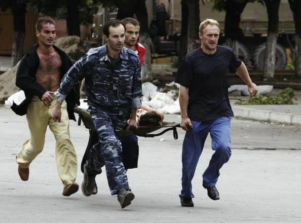 Un elev rănit la școala din Beslan este transportat la spital FOTO: Arhivă